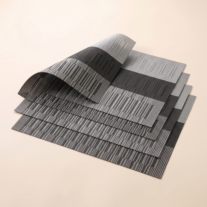 Woven Placemats – Wipe Clean in Black &amp; Gray – Block Stripe – stepped stack of four with top corner sweeping upward