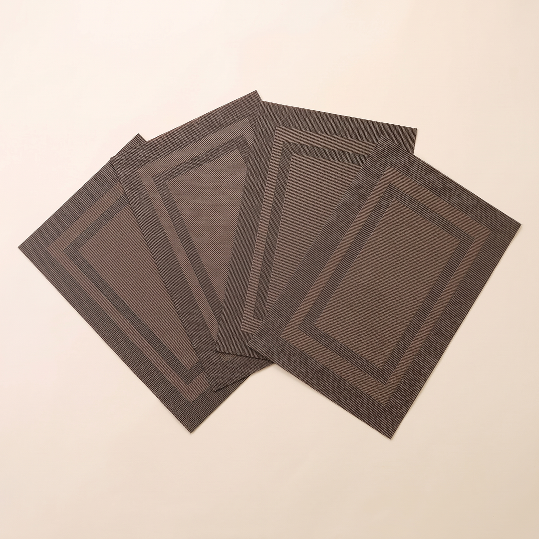 Woven Placemats – Wipe Clean in Brown – Frame – four mats overlapping in a slanted row, seen from above