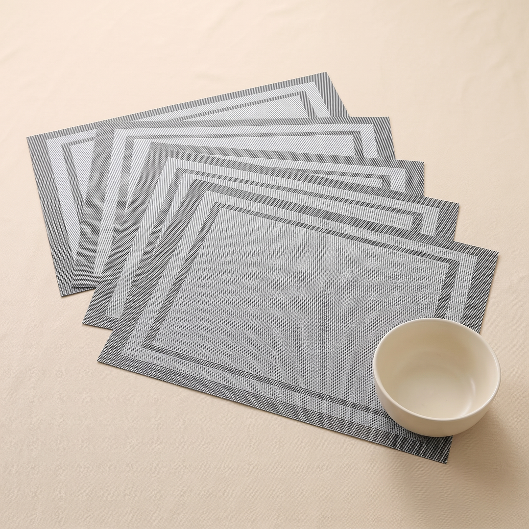 Woven Placemats – Wipe Clean in Gray – Frame – small bowl resting on five overlapping mats, seen from above
