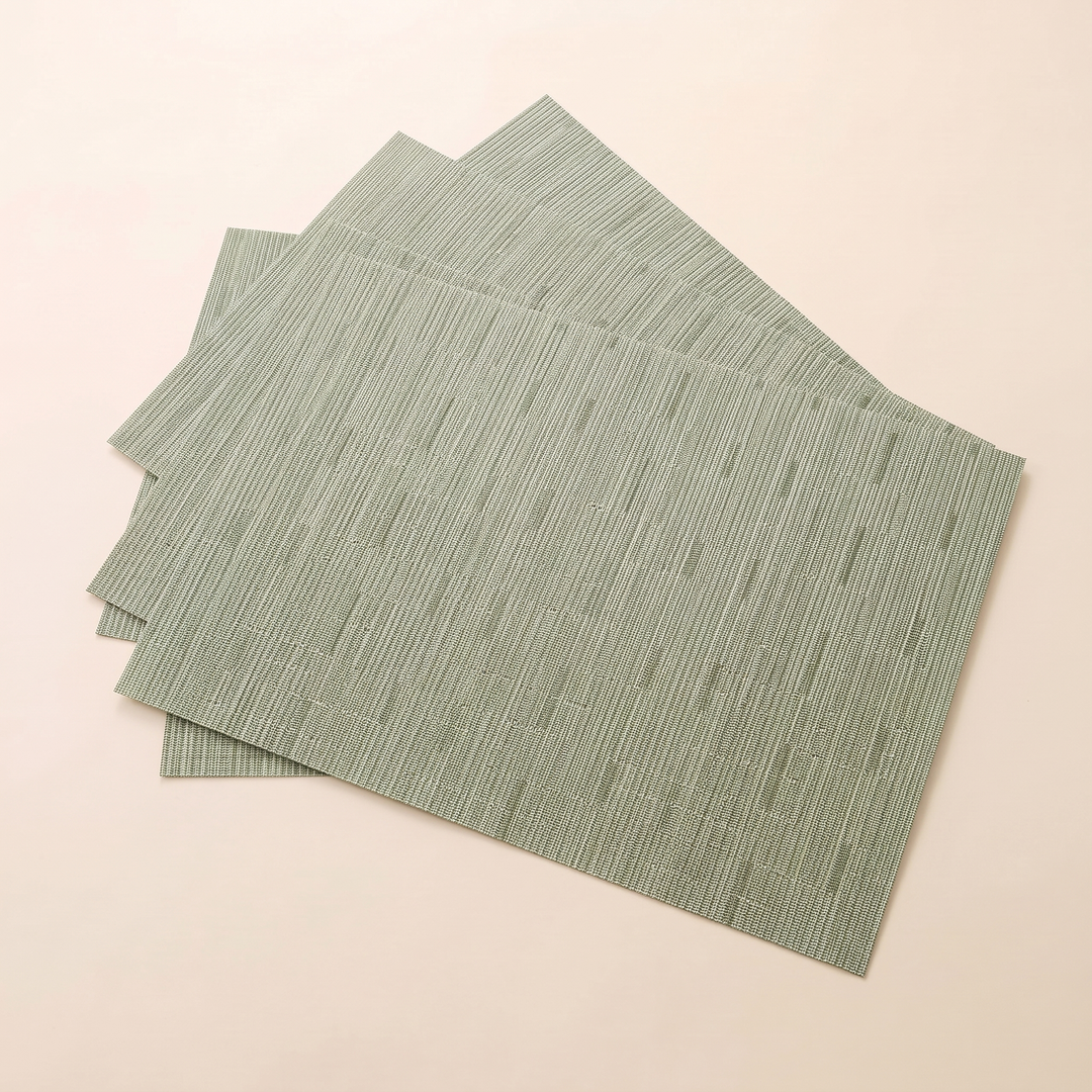 Woven Placemats – Wipe Clean in Sage – Dash Weave – mats stacked and twisted, edges peeking out behind top mat