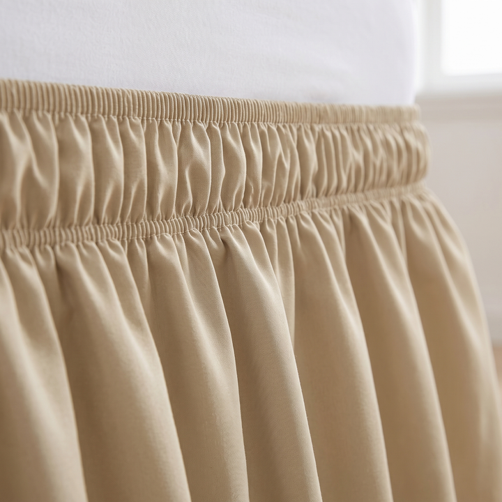 Wrap-Around Ruffled Bed Skirt in Beige – close-up of the gathered elastic band and ruffles under a white mattress