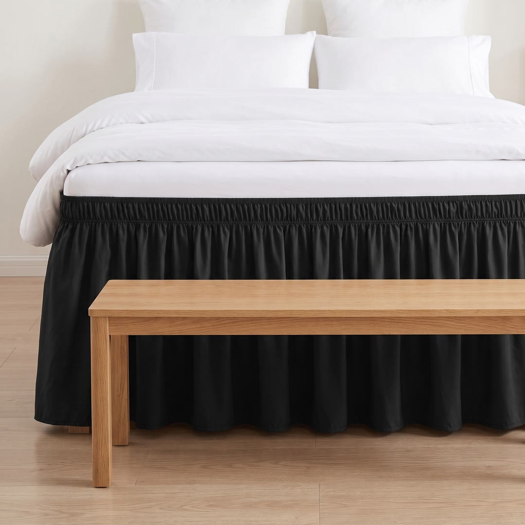 Wrap-Around Ruffled Bed Skirt in Black – front view on a white-bedded bed with a wooden bench at its foot