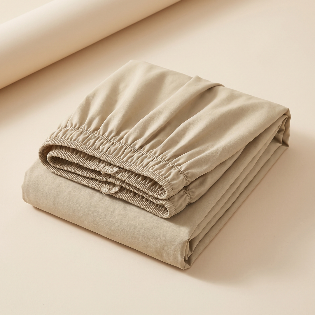 Wrap-Around Ruffled Bed Skirt in Beige – folded neatly with elastic edge on top, on a plain cream surface