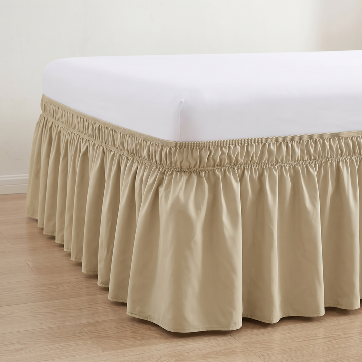 Wrap-Around Ruffled Bed Skirt in Beige – corner of a bed with white mattress on wood floor